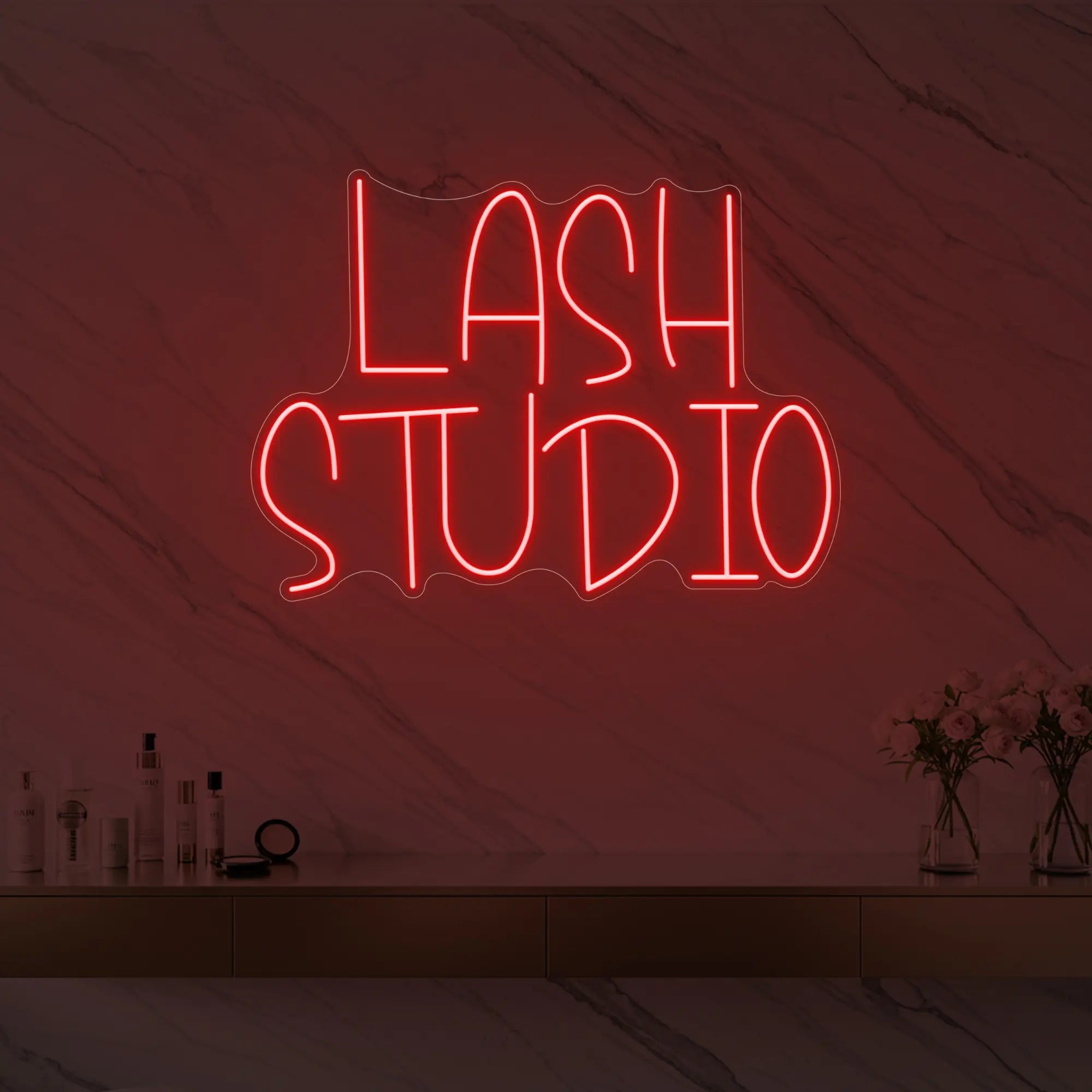 Photo of the 'LASH STUDIO' neon sign glowing in red against a styled interior wall.