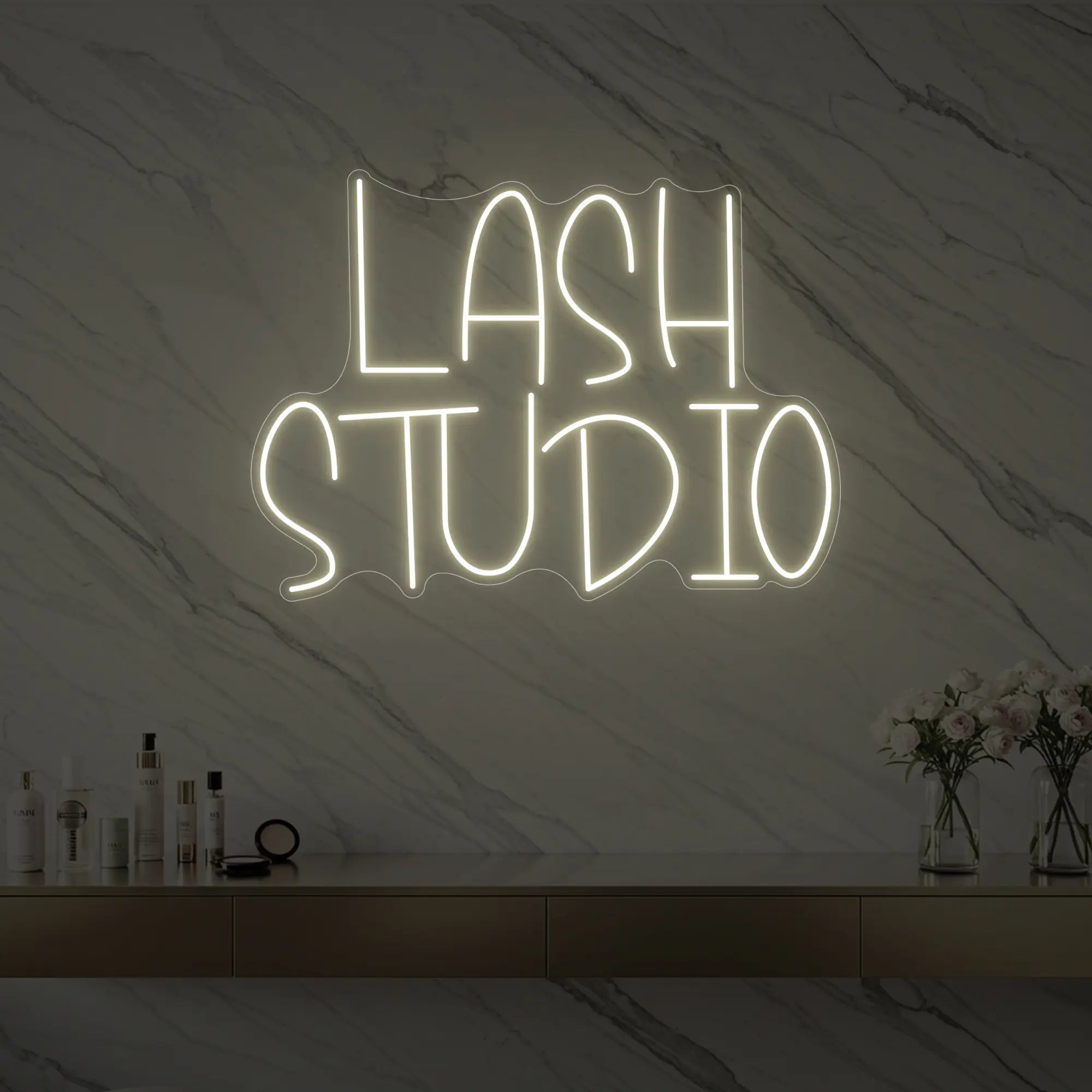 Photo of the 'LASH STUDIO' neon sign glowing in warm white against a styled interior wall.