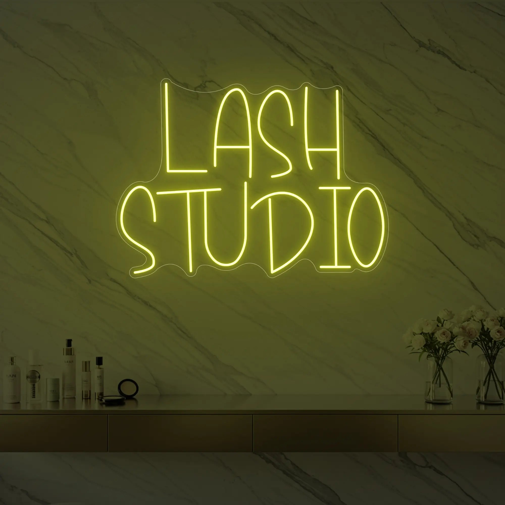 Photo of the 'LASH STUDIO' neon sign glowing in lemon yellow against a styled interior wall.
