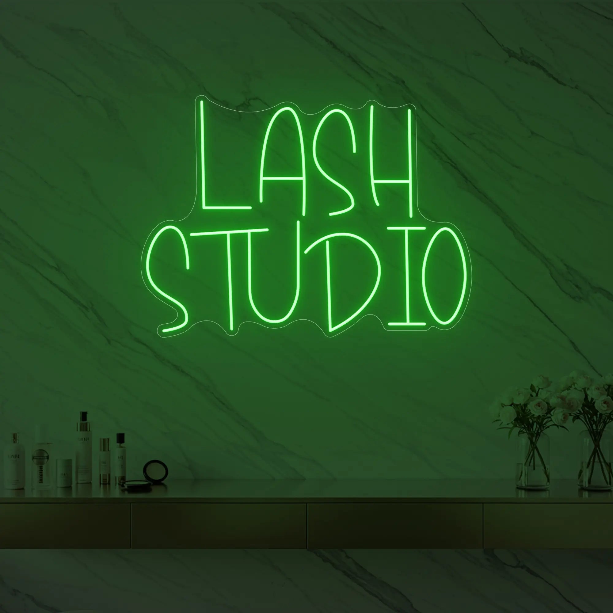 Photo of the 'LASH STUDIO' neon sign glowing in green against a styled interior wall.