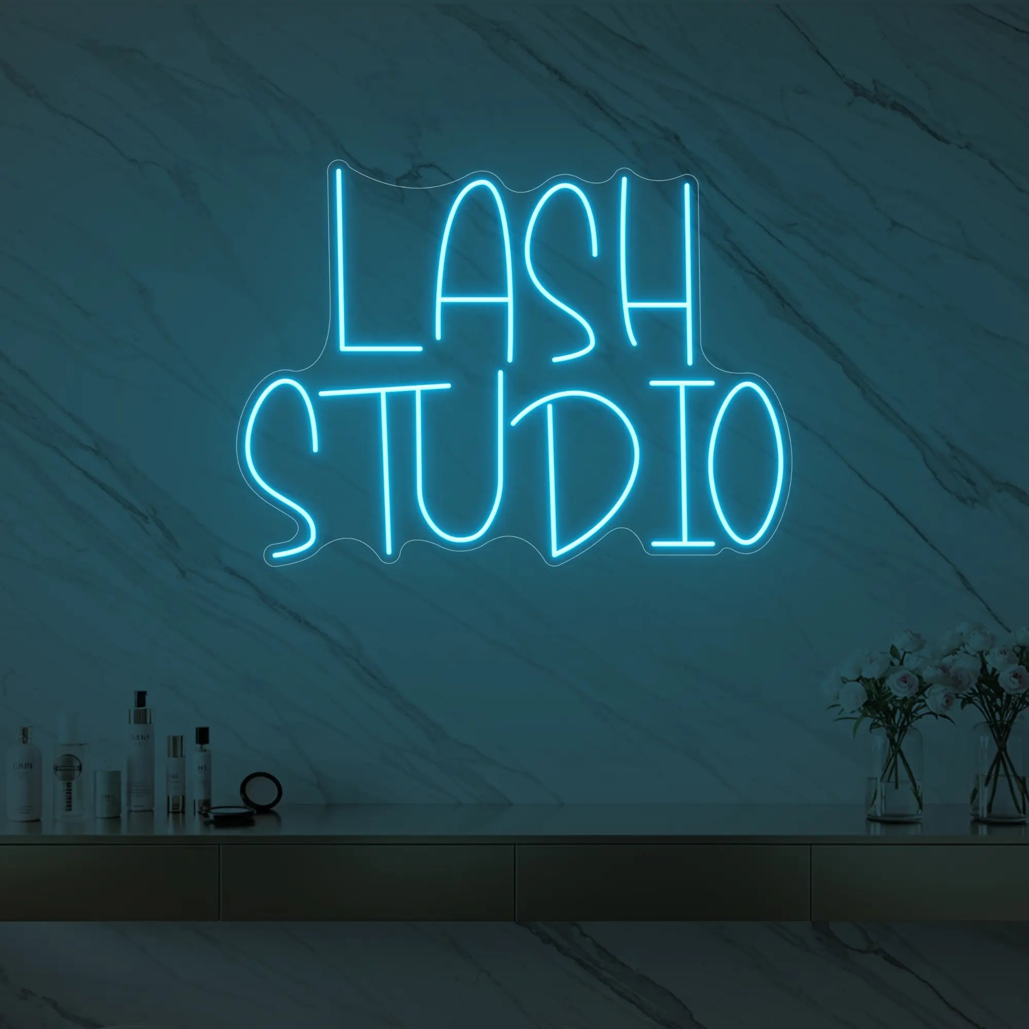 Photo of the 'LASH STUDIO' neon sign glowing in ice blue against a styled interior wall.
