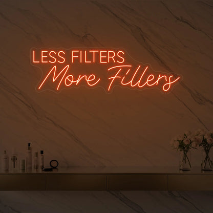 Photo of the 'LESS FILTERS MORE FILLERS' neon sign glowing in golden yellow against a marble wall.