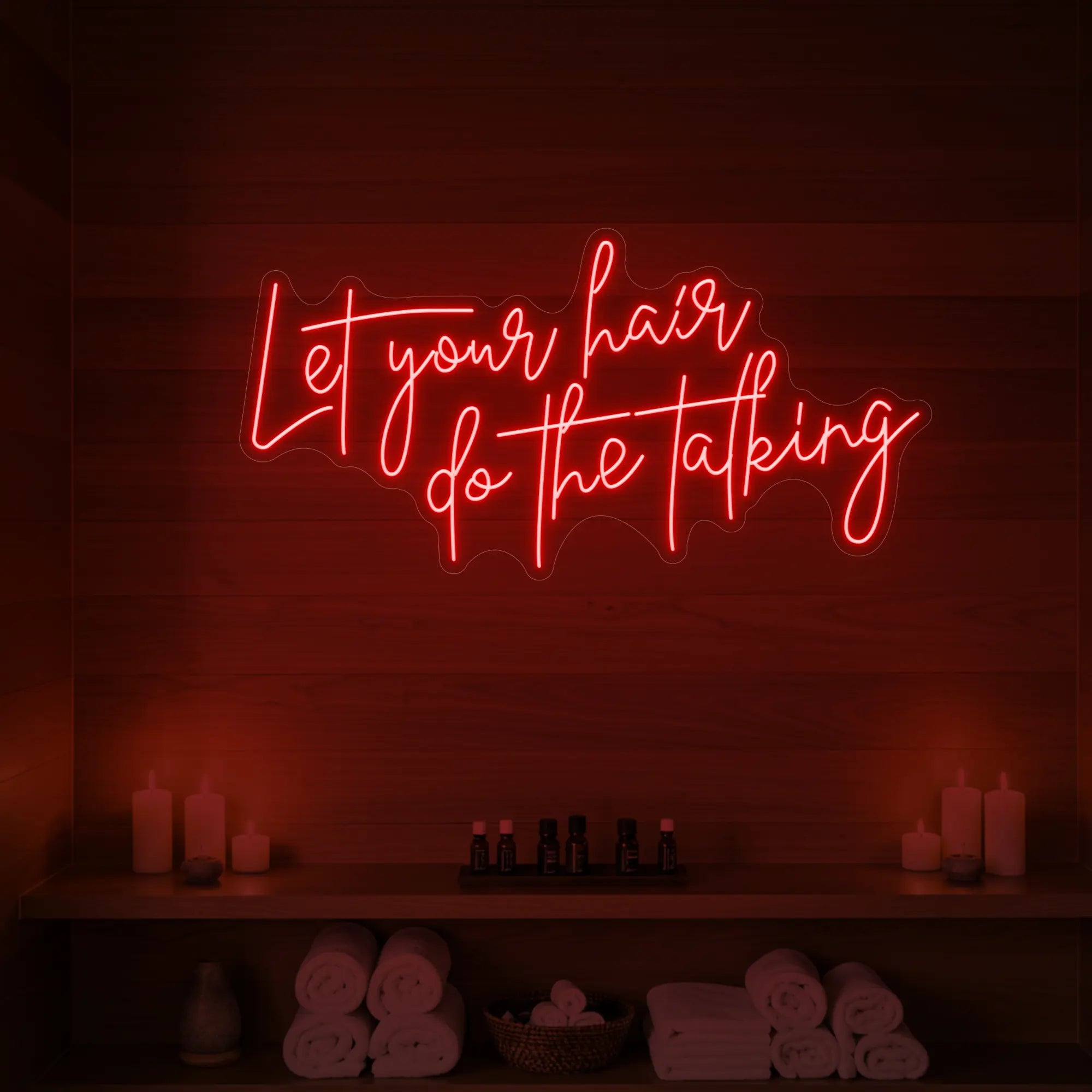 Photo of the 'Let your hair do the talking' neon sign glowing in red against a wooden wall.