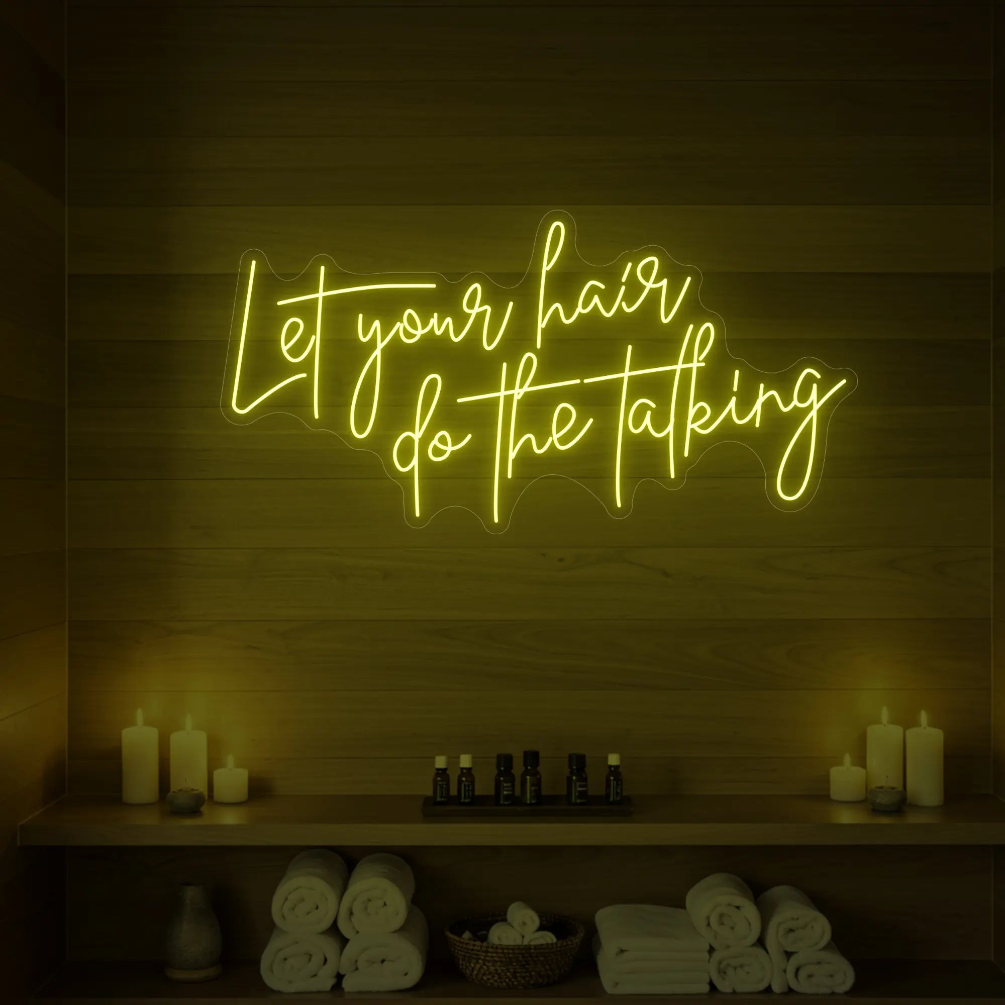 Photo of the 'Let your hair do the talking' neon sign glowing in lemon yellow against a wooden wall.