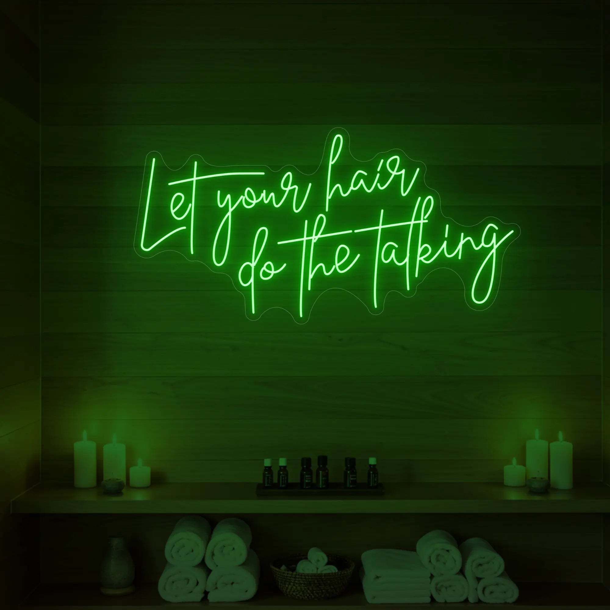 Photo of the 'Let your hair do the talking' neon sign glowing in green against a wooden wall.