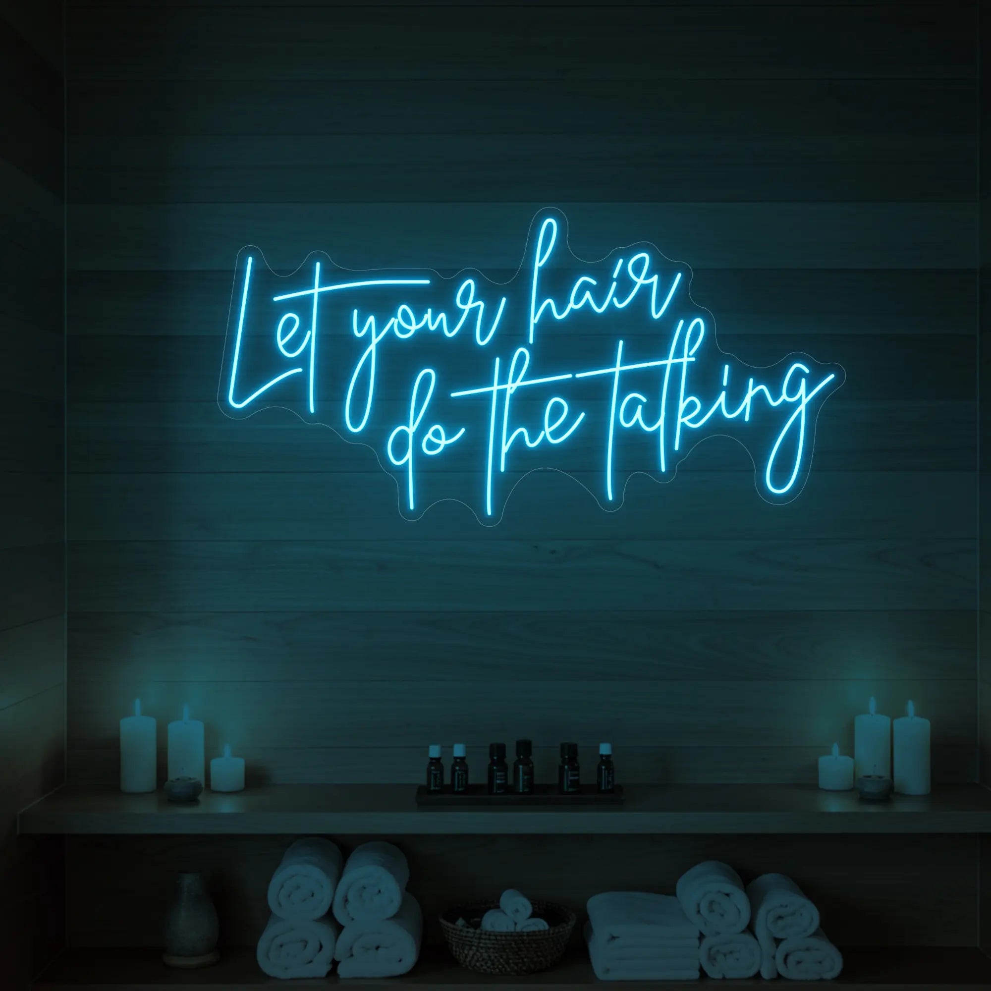 Photo of the 'Let your hair do the talking' neon sign glowing in ice blue against a wooden wall.