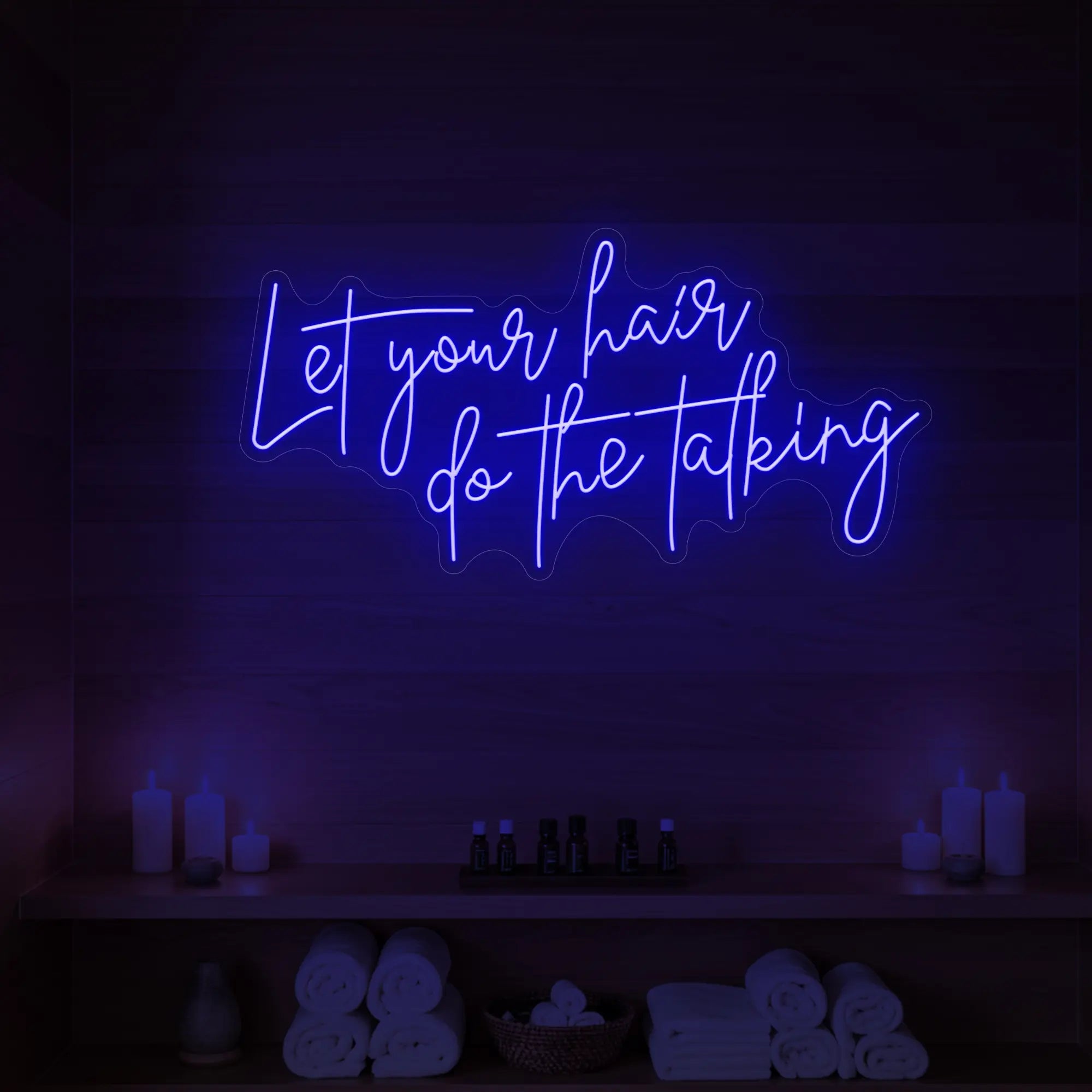 Photo of the 'Let your hair do the talking' neon sign glowing in deep blue against a wooden wall.