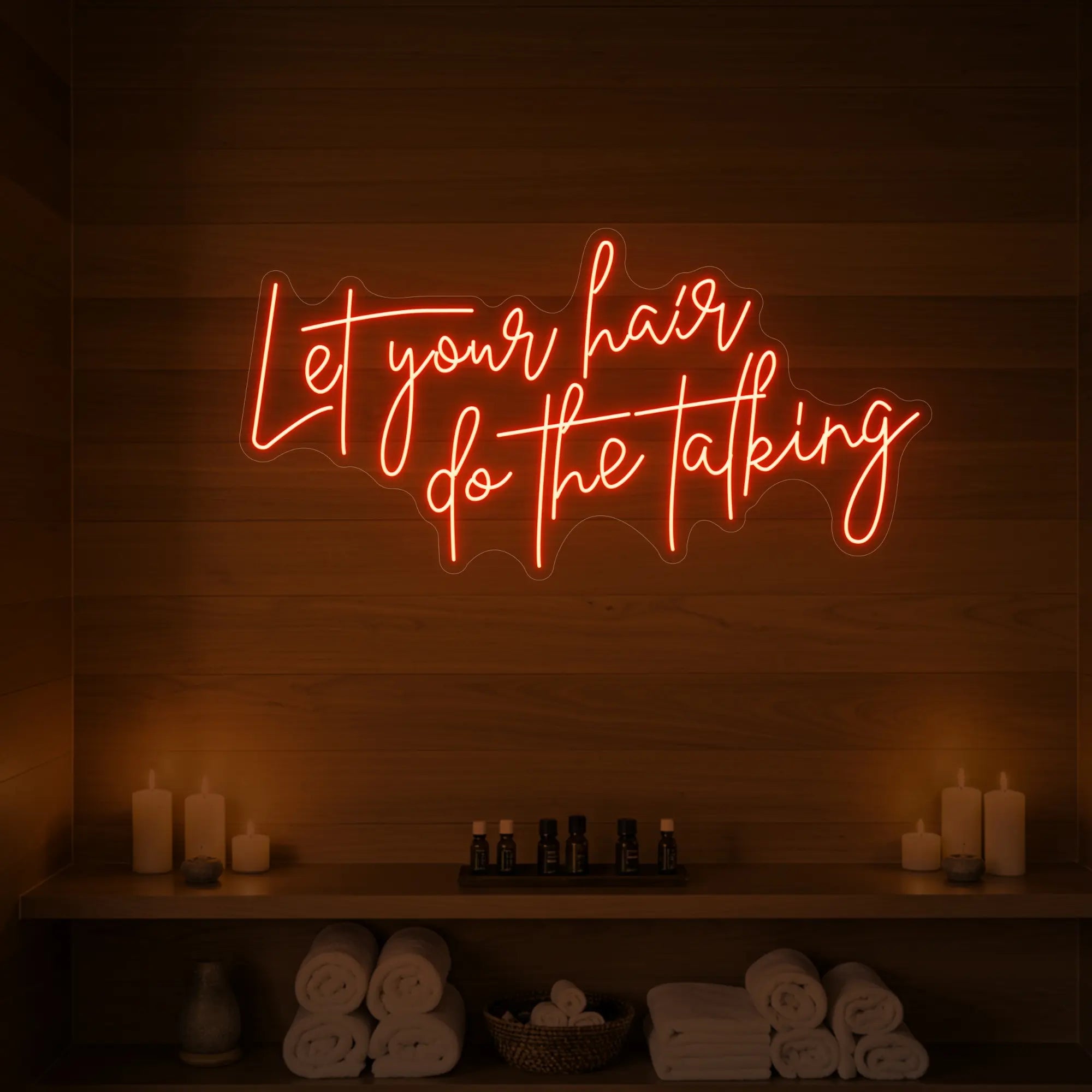 Photo of the 'Let your hair do the talking' neon sign glowing in golden yellow against a wooden wall.
