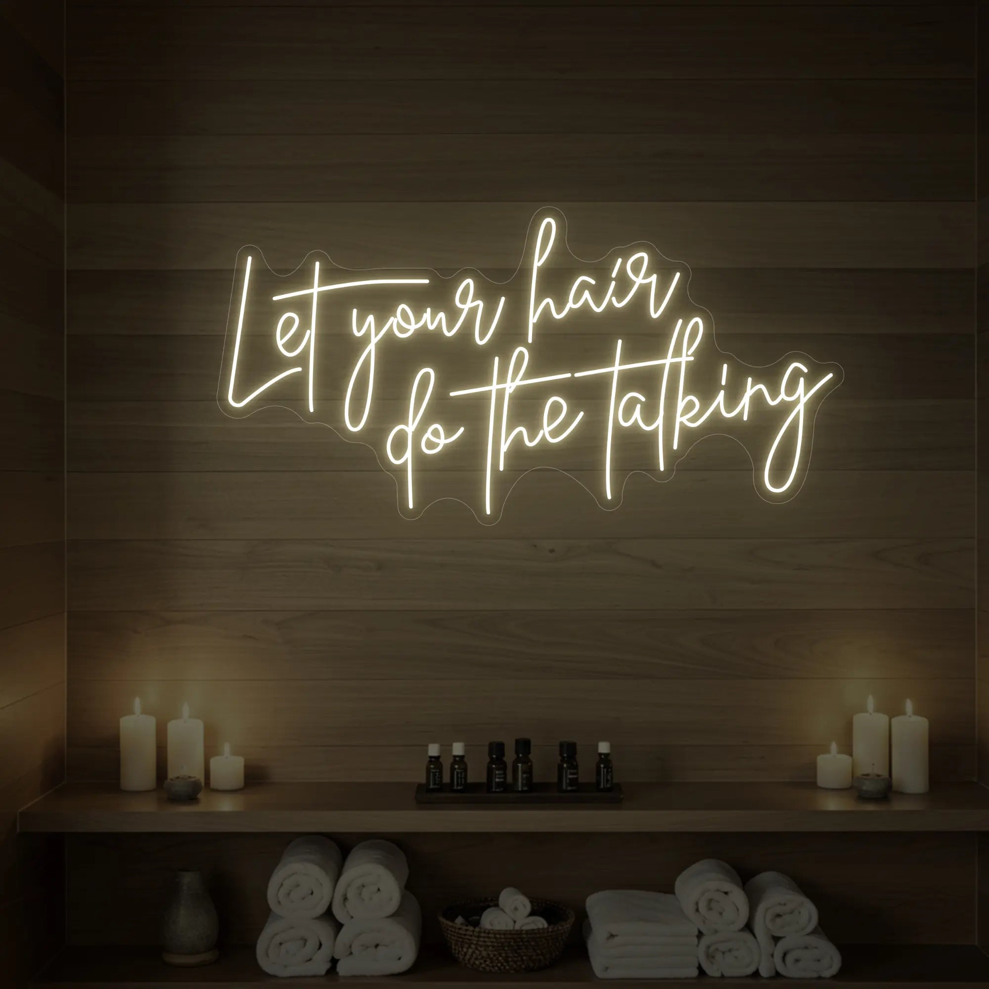 Photo of the 'Let your hair do the talking' neon sign glowing in warm white against a wooden wall.