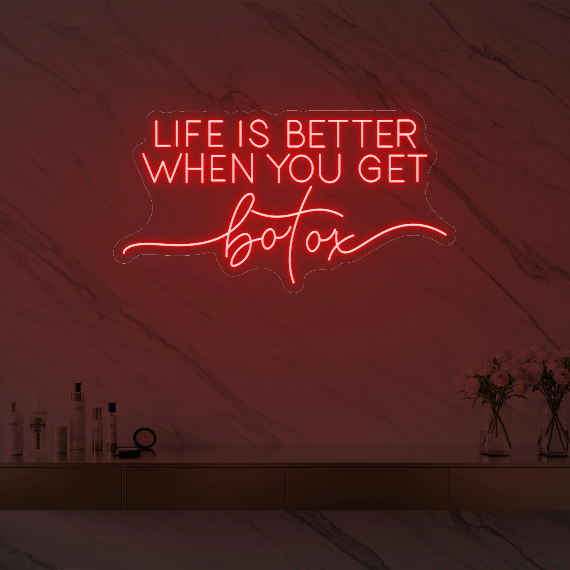Photo of the 'Life is Better When You Get Botox' neon sign glowing in red against a styled interior wall.