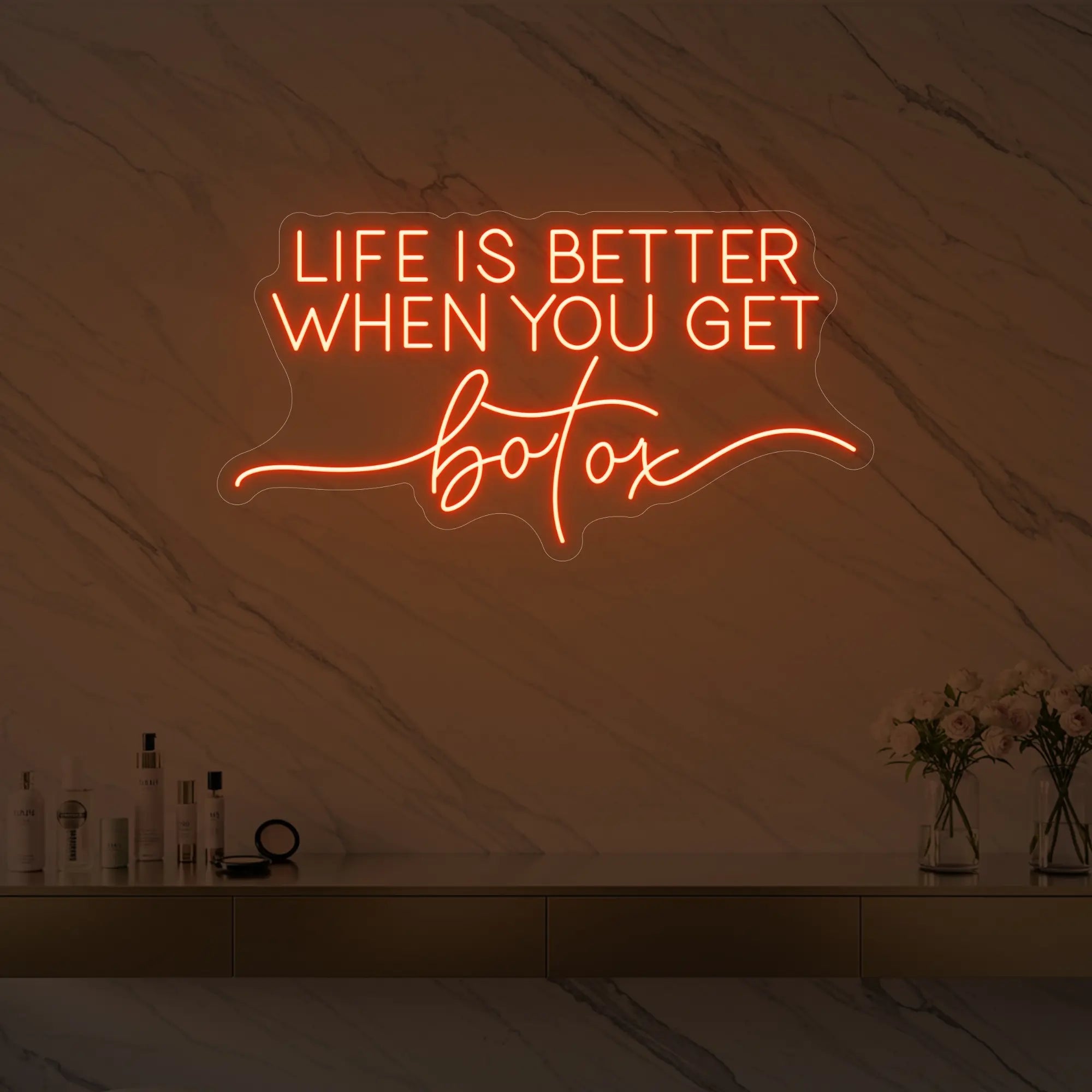 Photo of the 'Life is Better When You Get Botox' neon sign glowing in golden yellow against a styled interior wall.