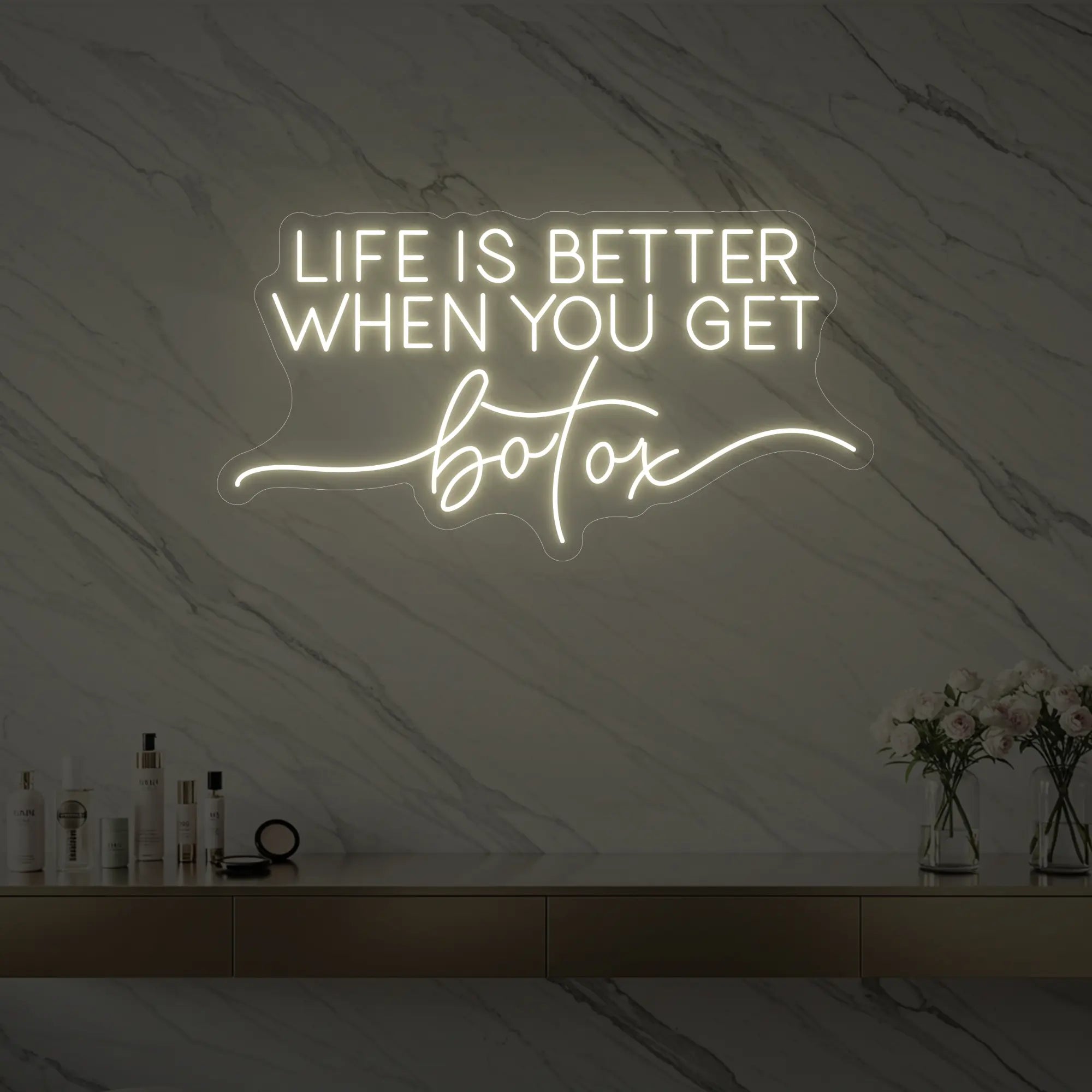 Photo of the 'Life is Better When You Get Botox' neon sign glowing in warm white against a styled interior wall.
