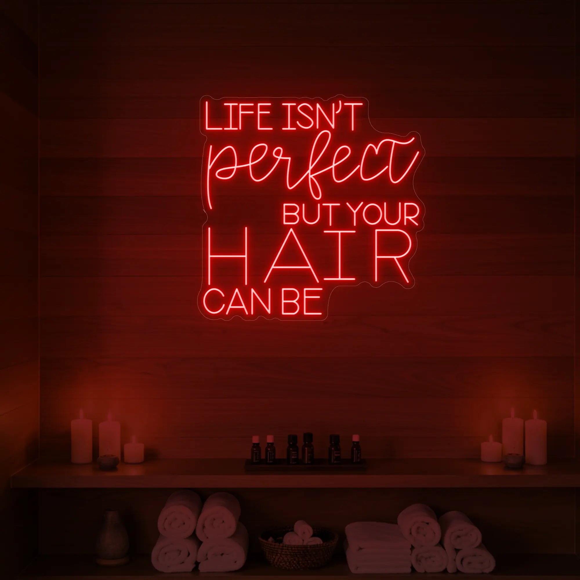 Photo of the 'Life isn’t perfect but your hair can be' neon sign glowing in red against a wood-paneled spa wall.