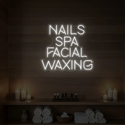 Photo of the 'Nails Spa Facial Waxing' neon sign glowing in cool white against a styled interior wall.