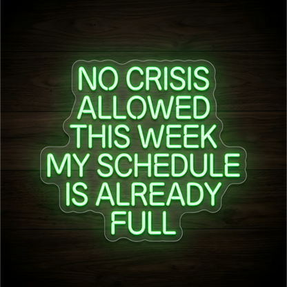 No Crisis Allowed LED Neon Sign displaying “NO CRISIS ALLOWED THIS WEEK MY SCHEDULE IS ALREADY FULL” in bright green uppercase lettering on contoured clear acrylic against a dark wood background, suited to home offices and workplace decor.