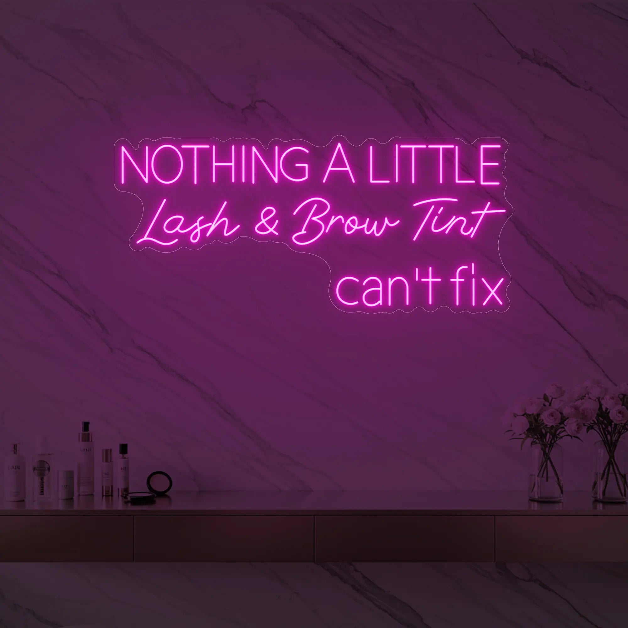 Photo of the 'Nothing a Little Lash & Brow Tint Can’t Fix' neon sign glowing in light pink against a styled interior wall.