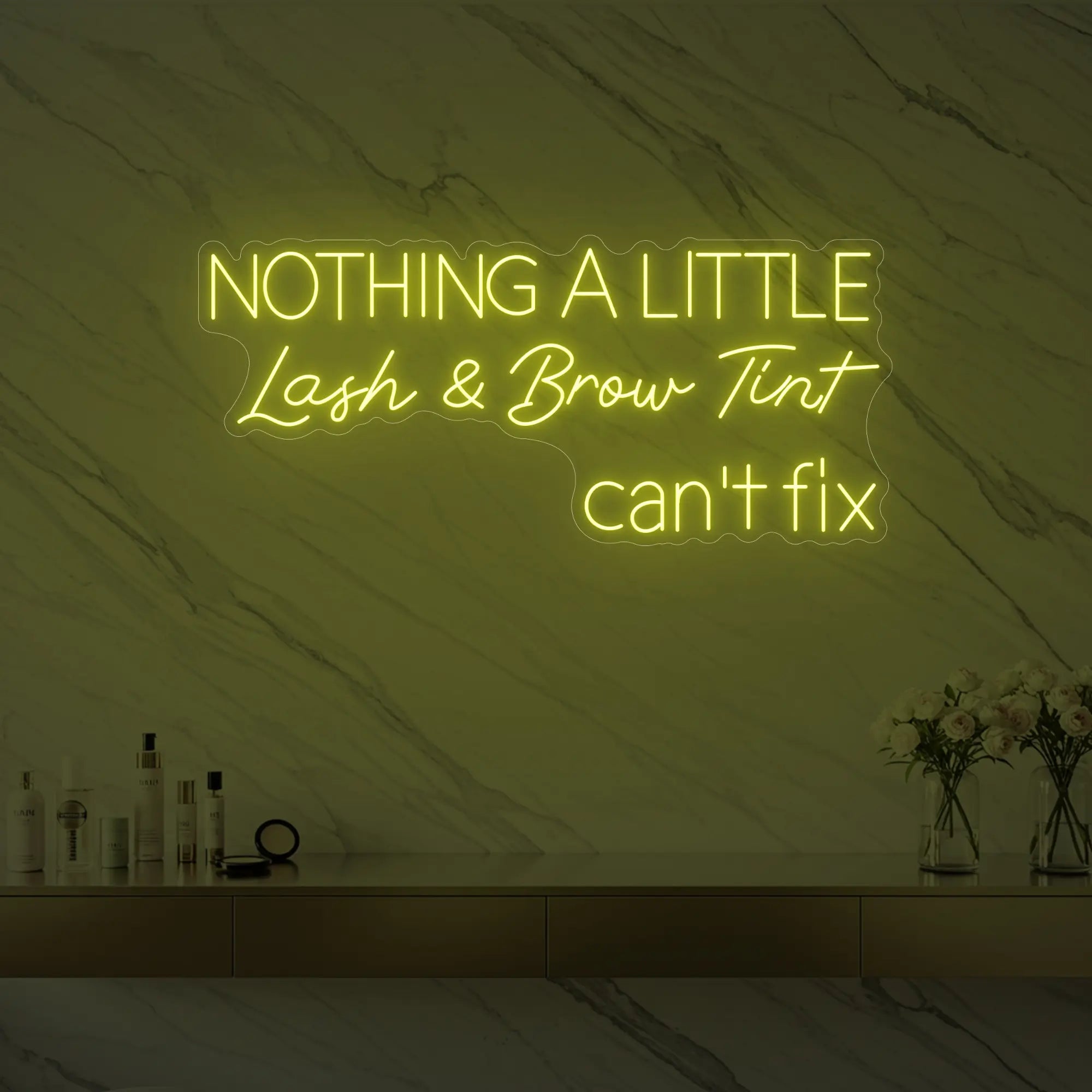 Photo of the 'Nothing a Little Lash & Brow Tint Can’t Fix' neon sign glowing in lemon yellow against a styled interior wall.