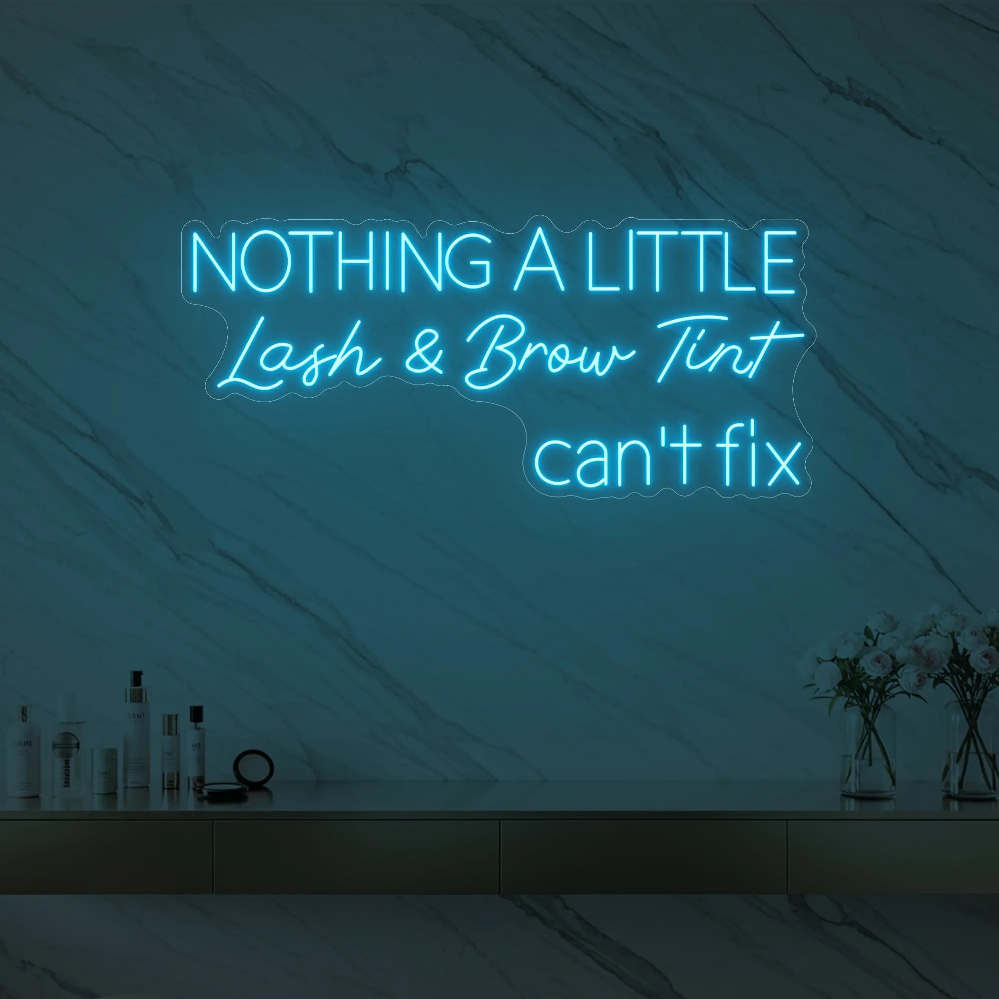 Photo of the 'Nothing a Little Lash & Brow Tint Can’t Fix' neon sign glowing in ice blue against a styled interior wall.