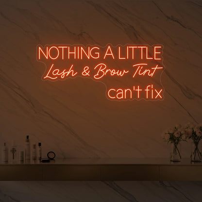 Photo of the 'Nothing a Little Lash & Brow Tint Can’t Fix' neon sign glowing in golden yellow against a styled interior wall.
