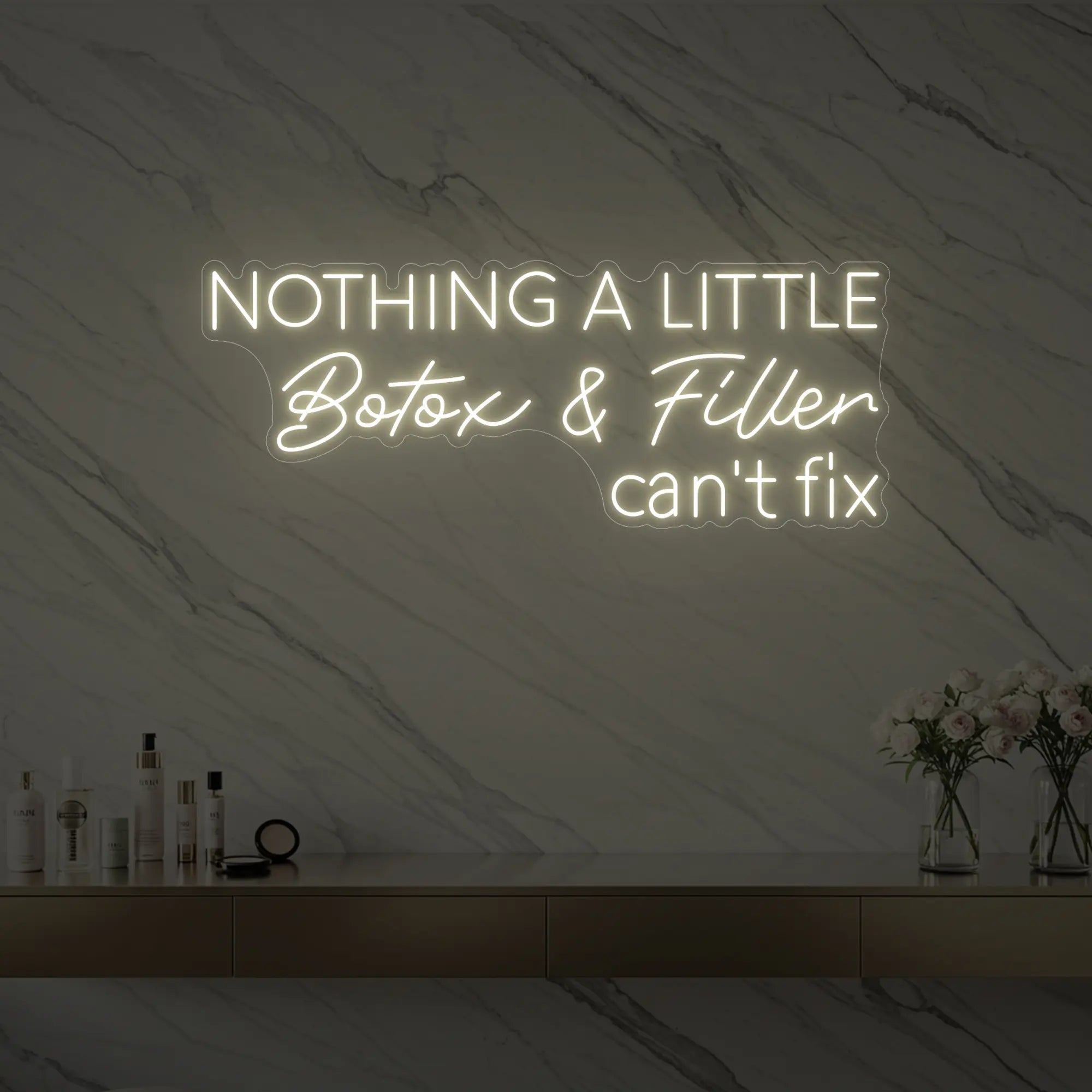 Photo of the 'Nothing a Little Botox & Filler Can’t Fix' neon sign glowing in warm white against a styled interior wall.