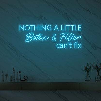Photo of the 'Nothing a Little Botox & Filler Can’t Fix' neon sign glowing in ice blue against a styled interior wall.