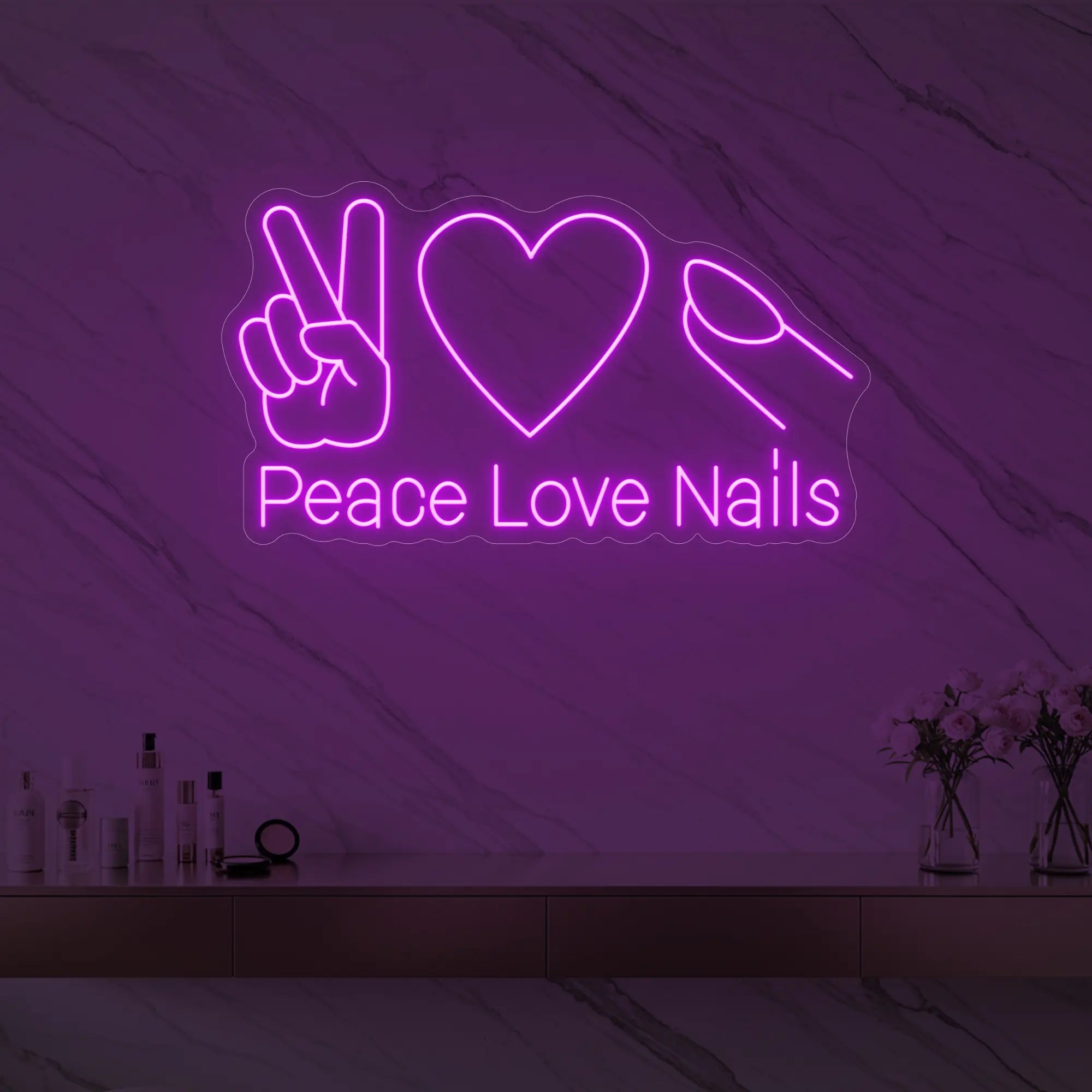 Photo of the 'Peace Love Nails' neon sign glowing in deep pink against a styled interior wall.
