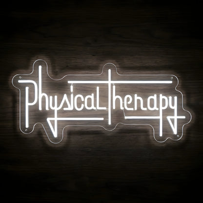 Physical Therapy Barbell LED Neon Sign featuring bright white stylized lettering with geometric line accents on clear cut-to-shape acrylic against a dark wooden wall.