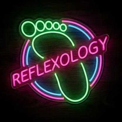 Reflexology Foot Care LED Neon Sign featuring a green footprint outline, pink REFLEXOLOGY lettering, and blue and pink circular accents on clear acrylic backing against a dark wooden wall.