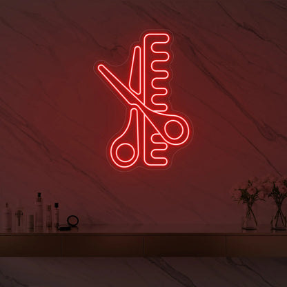 Photo of the 'Scissors and Comb' neon sign glowing in red against a styled interior wall.