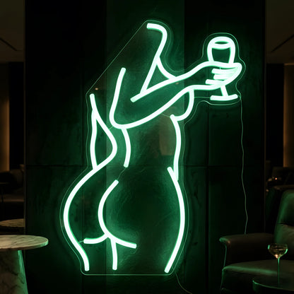 Photo of the 'Sexy Drink' neon sign glowing in green against a chic nightlife-inspired wall.