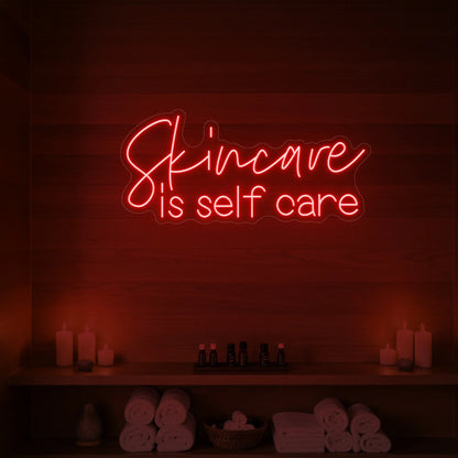 Photo of the 'Skincare is Self Care' neon sign glowing in red against a styled interior wall.