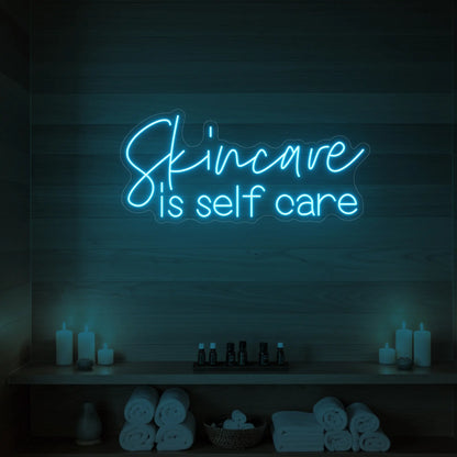 Photo of the 'Skincare is Self Care' neon sign glowing in ice blue against a styled interior wall.
