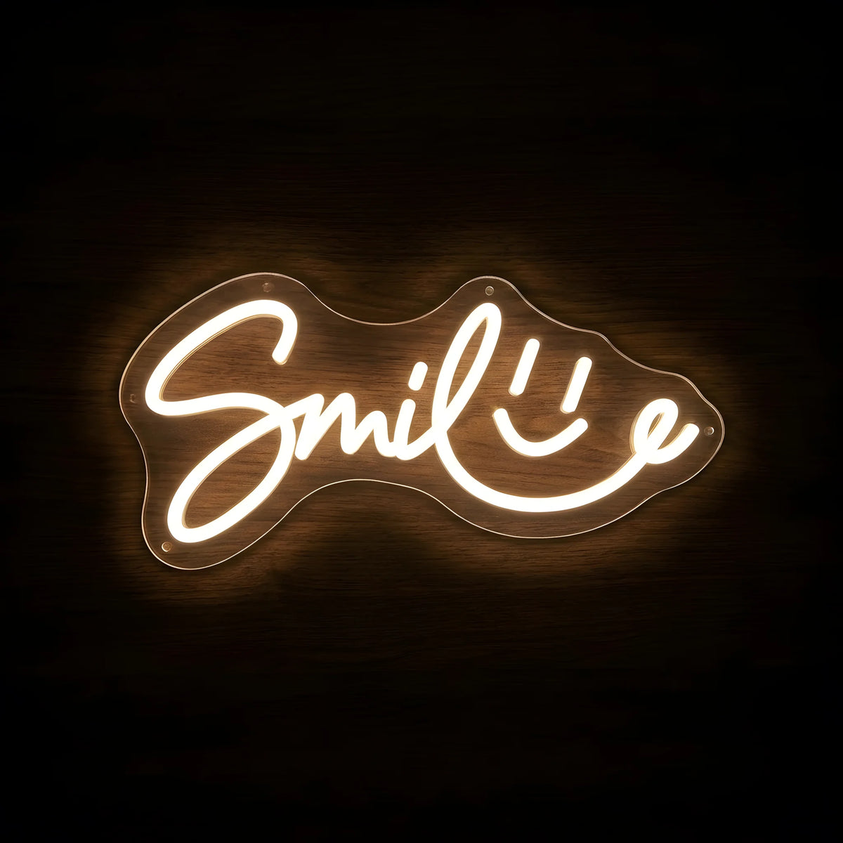 Smile Wordmark LED neon sign featuring elegant warm white Smile script lettering with an integrated smiley face on clear acrylic backing for dental clinic and cosmetic dentistry wall decor.