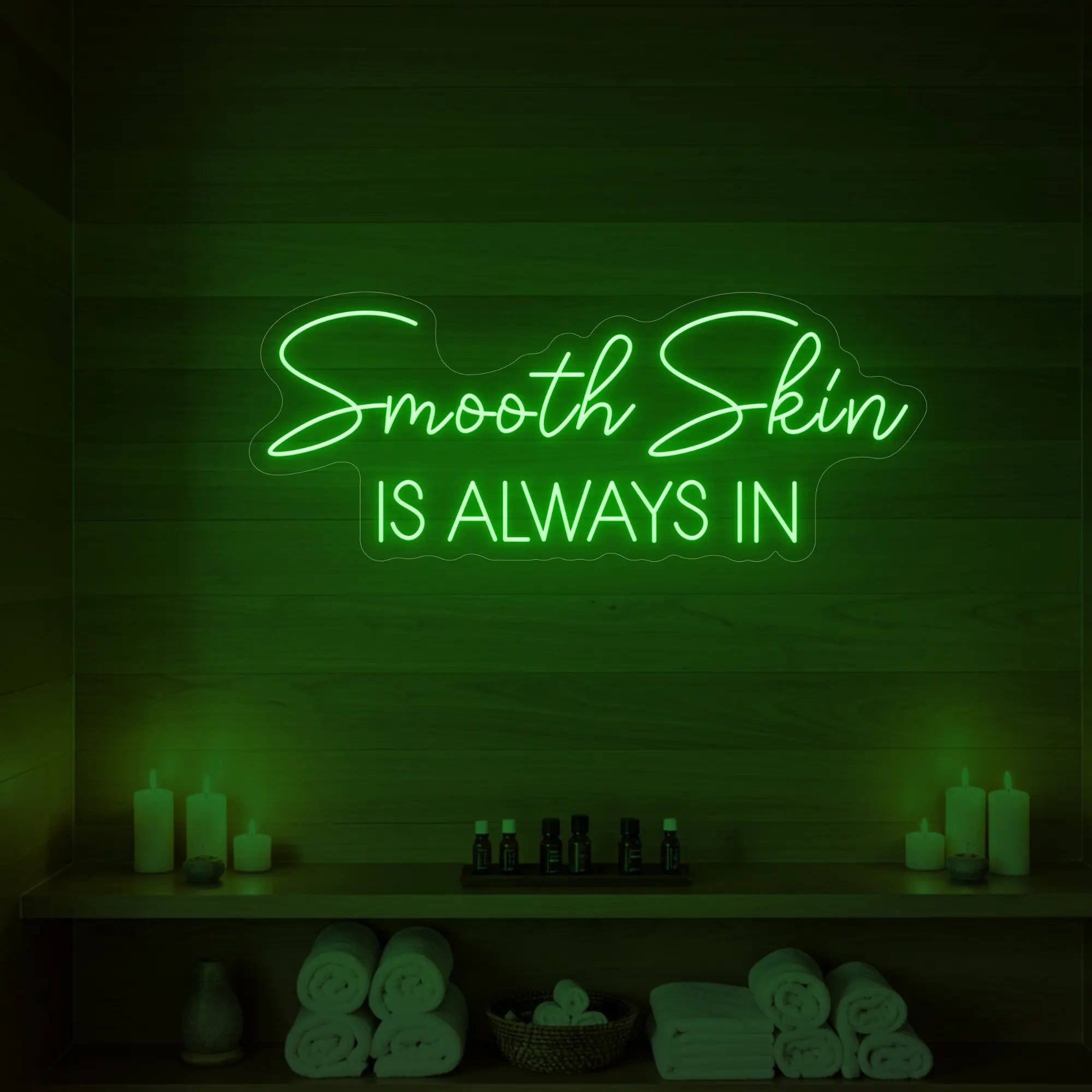 Photo of the 'Smooth Skin Is Always In' neon sign glowing in green against a styled interior wall.