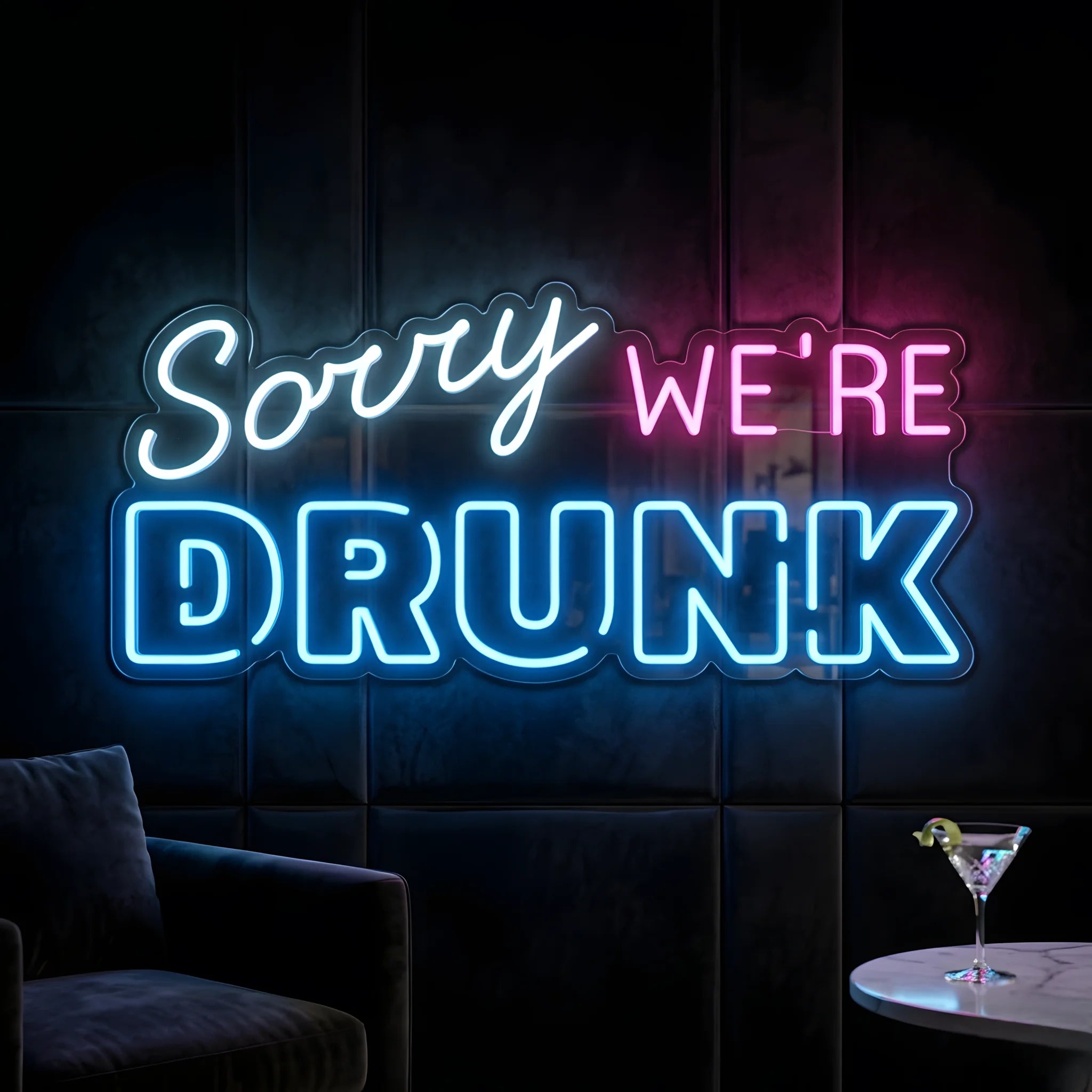 Photo of the 'Sorry We’re Drunk' neon sign glowing in multi-color against a fun bar-inspired wall.