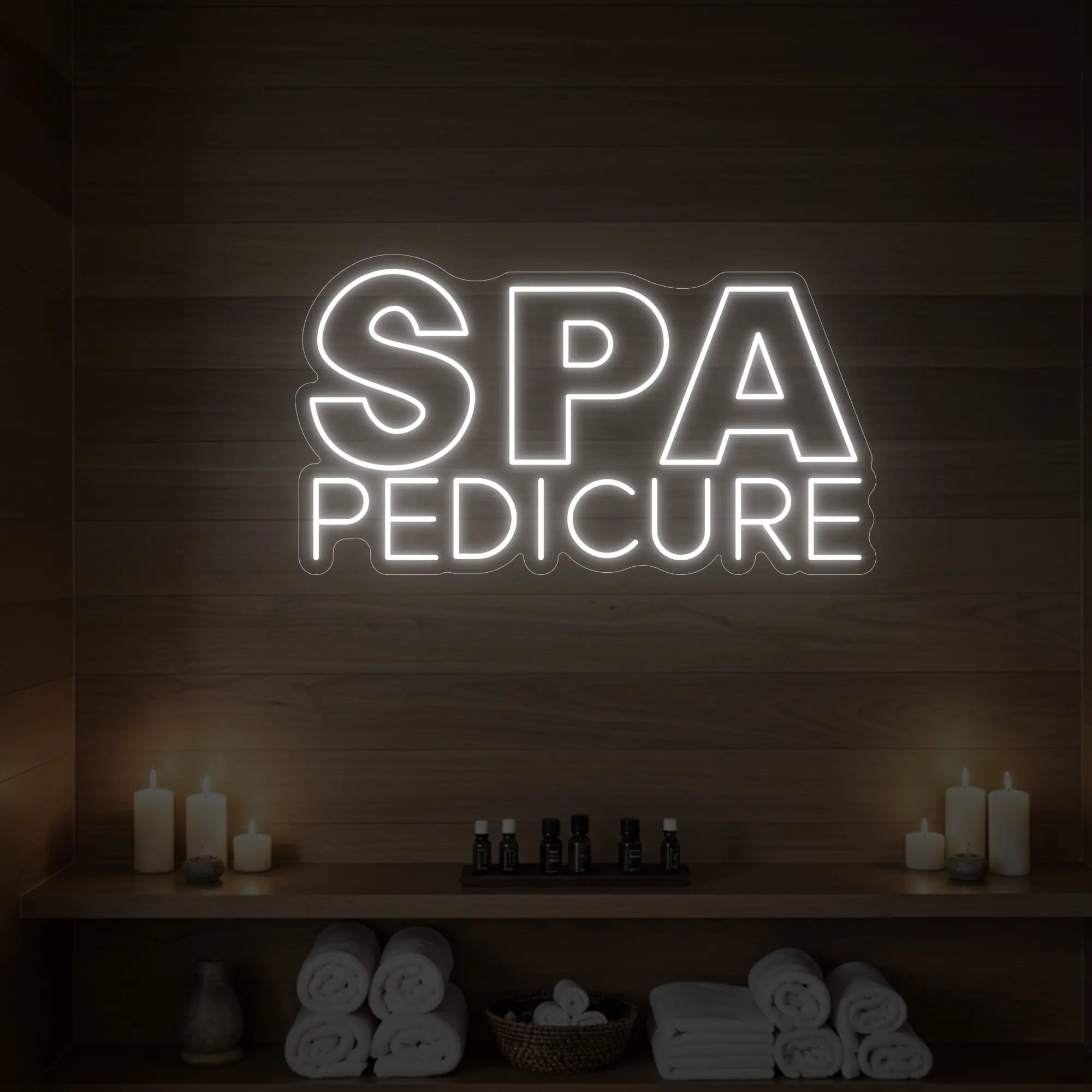 Photo of the 'Spa Pedicure' neon sign glowing in cool white against a styled interior wall.