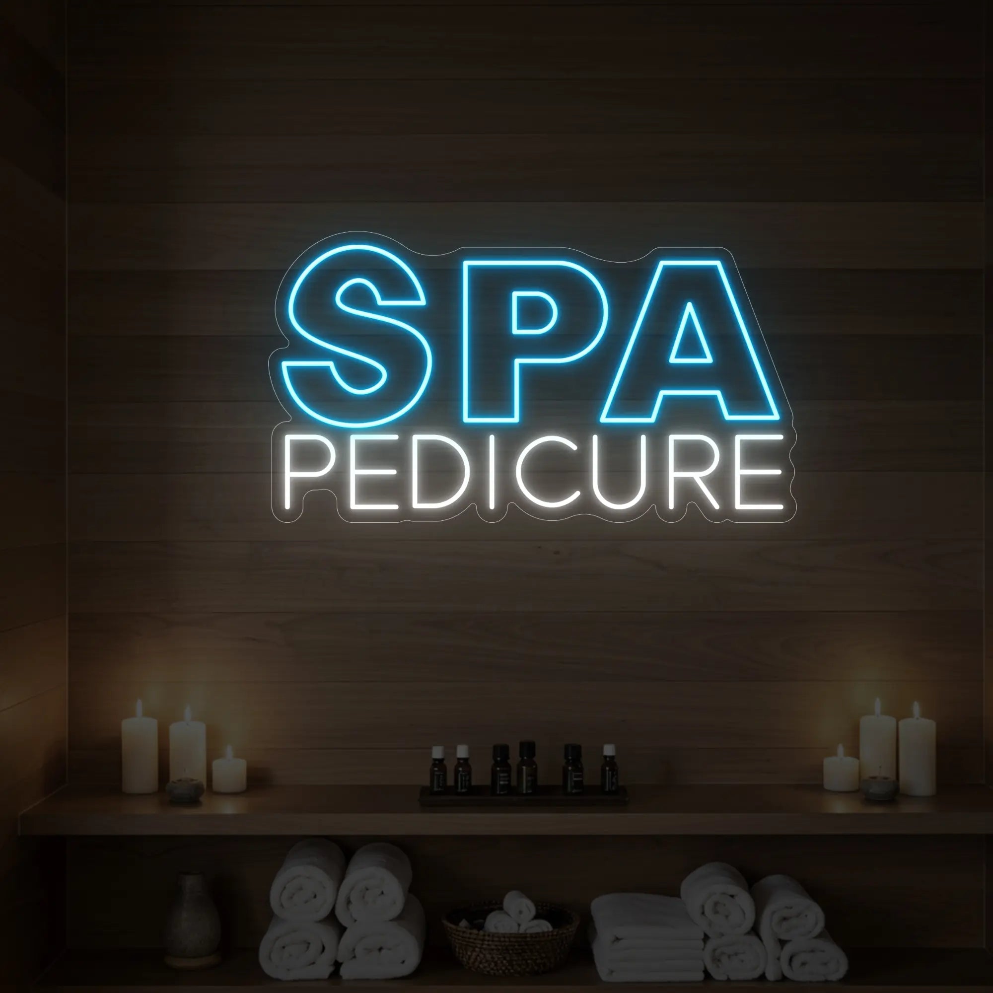 Photo of the 'Spa Pedicure' neon sign glowing in ice blue against a styled interior wall.