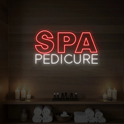 Photo of the 'Spa Pedicure' neon sign glowing in red against a styled interior wall.