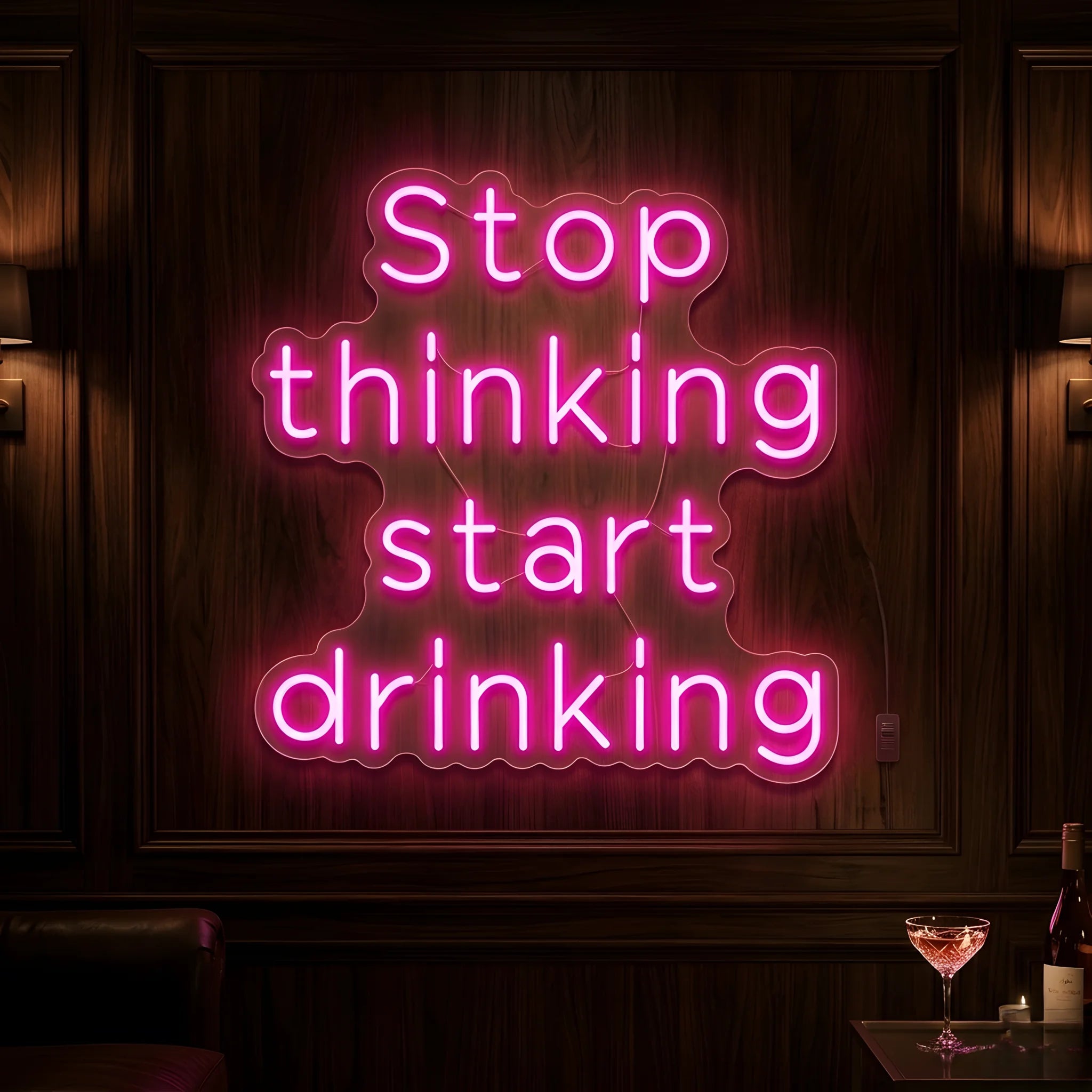 Photo of the 'Stop Thinking Start Drinking Version 1' neon sign glowing in pink against a nightlife-inspired wall.