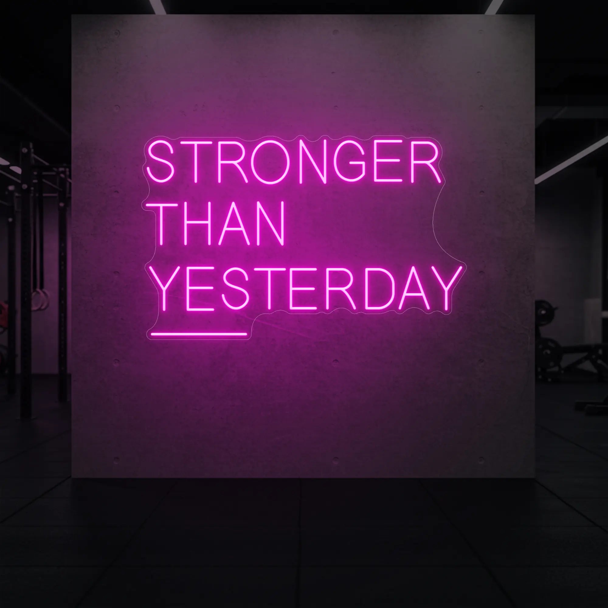 'Stronger Than Yesterday' neon sign glowing in light pink against a styled interior wall.
