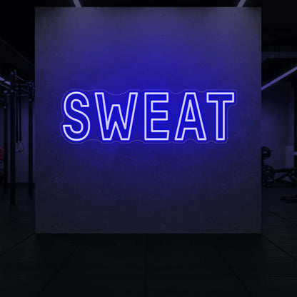 'SWEAT' neon sign glowing in deep blue against a styled interior wall.