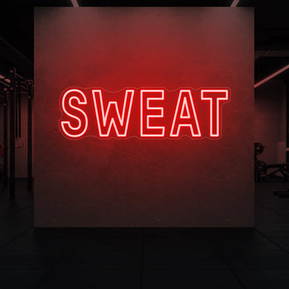 'SWEAT' neon sign glowing in red against a styled interior wall.