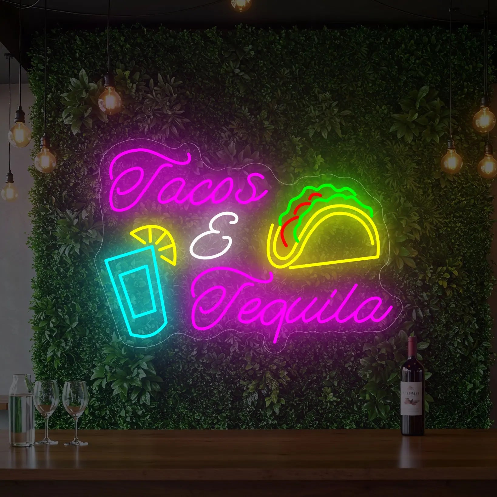 Photo of the 'TACOS & TEQUILA' neon sign glowing in multi-color against a styled interior wall.