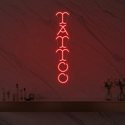 Photo of the 'Vertical Tattoo' neon sign glowing in red against a styled interior wall.