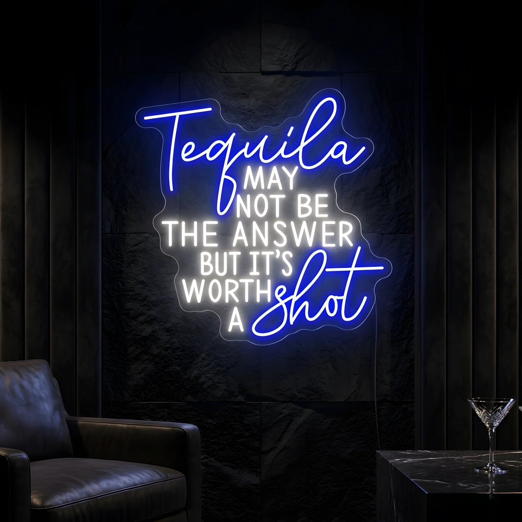 Photo of the 'Tequila May Not Be The Answer But It’s Worth a Shot' neon sign glowing in multi-color against a tequila bar-inspired wall.