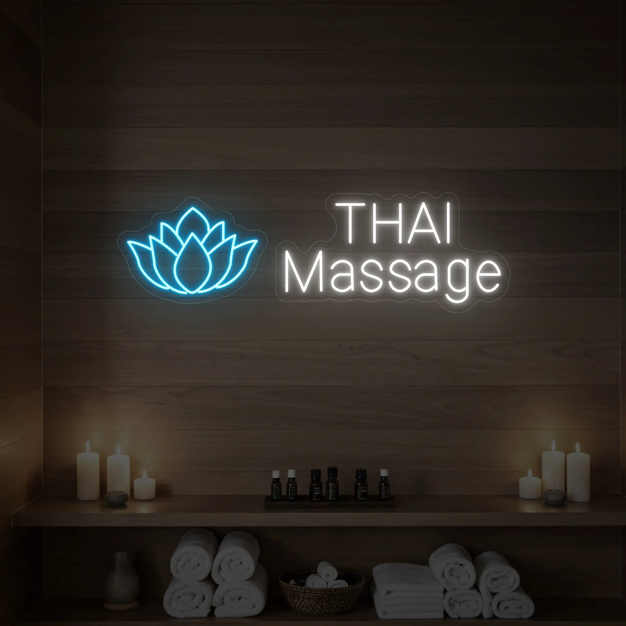 Photo of the 'Thai Massage' neon sign glowing in ice blue against a styled interior wall.