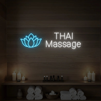 Photo of the 'Thai Massage' neon sign glowing in ice blue against a styled interior wall.