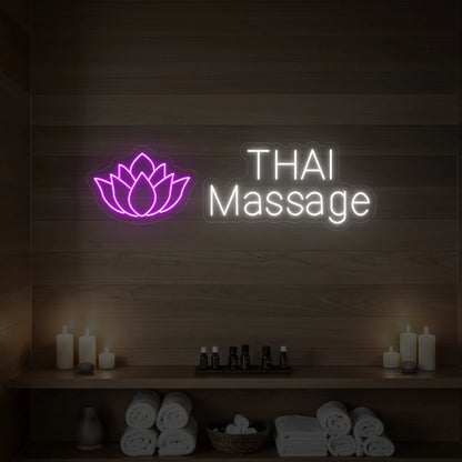 Photo of the 'Thai Massage' neon sign glowing in deep pink against a styled interior wall.