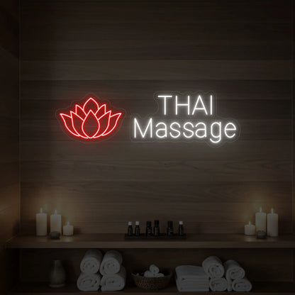 Photo of the 'Thai Massage' neon sign glowing in red against a styled interior wall.