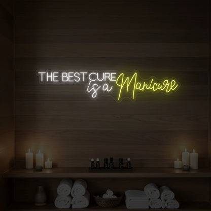 Photo of the 'The Best Cure is a Manicure' neon sign glowing in lemon yellow against a styled interior wall.